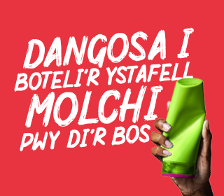 Llaw yn dal potel siampŵ gyda'r slogan Dangosa i boteli'r ystafell molchi pwy di'r bos