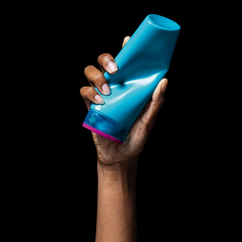 Hand holding a crushed bottle